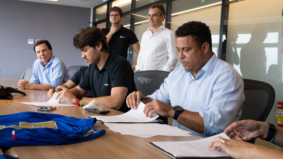 Ronaldo assina contrato com o Cruzeiro, sob olhar de Régis Campos, conselheiro do clube — Foto: Divulgação/ XP Investimentos