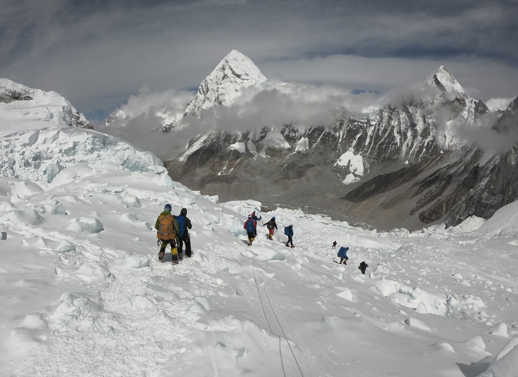 A foto, de 29 de abril, mostra escaladores andando perto do acampamento 1 no Monte Everest, enquanto se preparam para para subir pela face sul da montanha a partir do Nepal. — Foto: Phunjo Lama / AFP