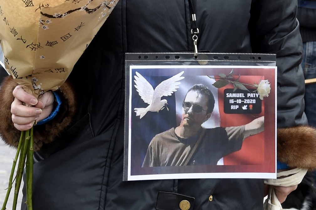 Manifestante exibe foto do professor Samuel Paty, decapitado nos subúrbios de Paris, na França — Foto: François Lo Presti/AFP