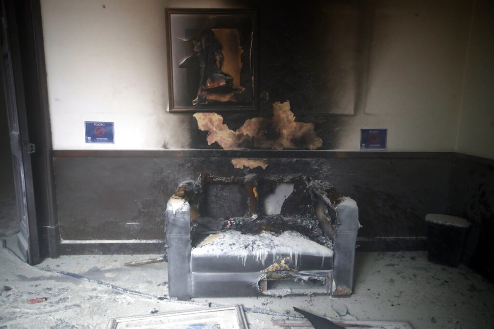 Sofá e quadro destruídos pelo fogo no Congresso da Guatemala neste sábado (21) — Foto: Moises Castillo/AP Photo