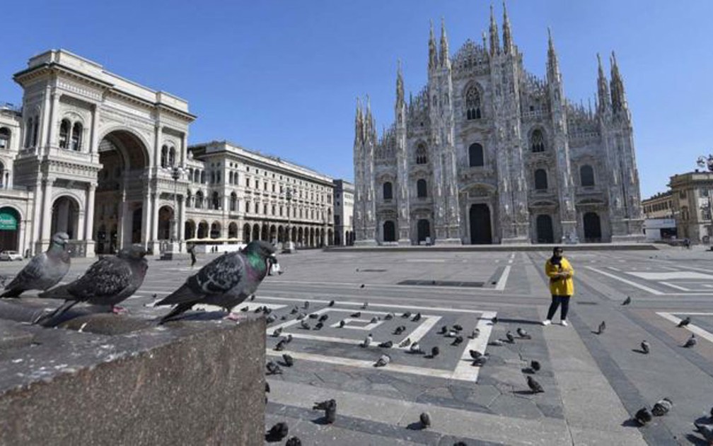 A Praça Duomo, em Milão, está deserta. Em toda a Itália, o governo determinou medidas de restrição da circulação de pessoas e ordenou o fechamento de estabelecimentos comerciais, exceto mercados e farmácias  — Foto: Daniel Dal Zennaro/EPA/BBC