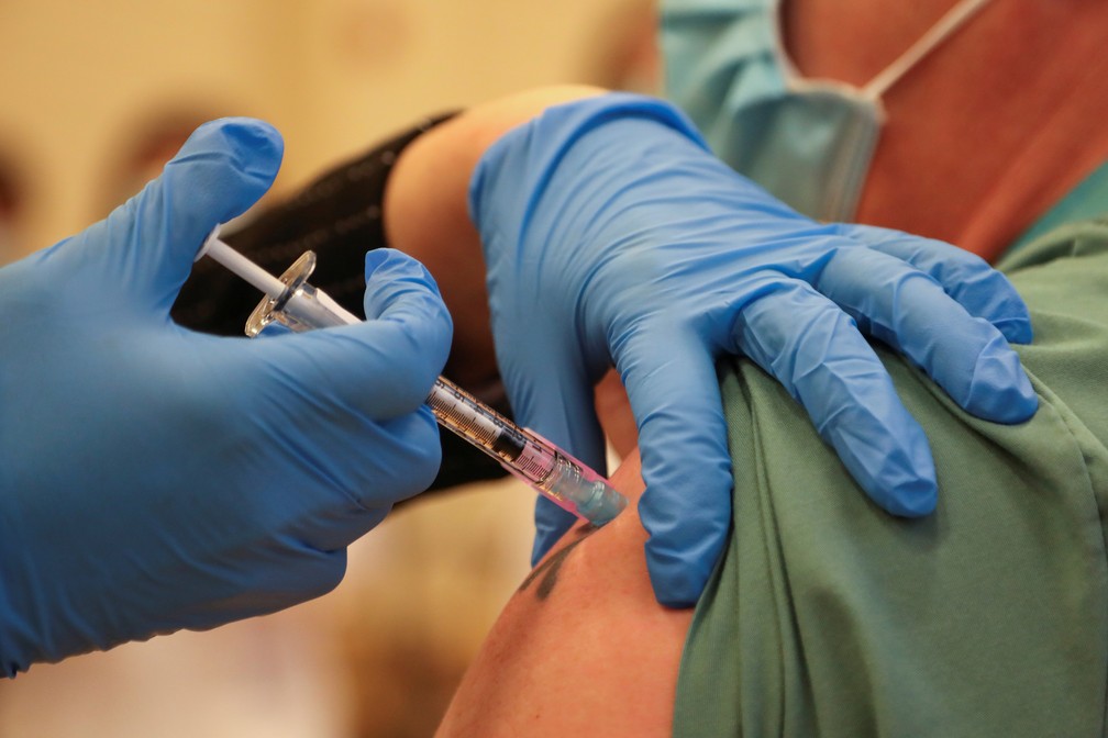 Derek Thompson recebeu dose da vacina da Pfizer no The Michener Institute, em Toronto, Ontário, Canadá — Foto: Carlos Osorio/Pool/AFP