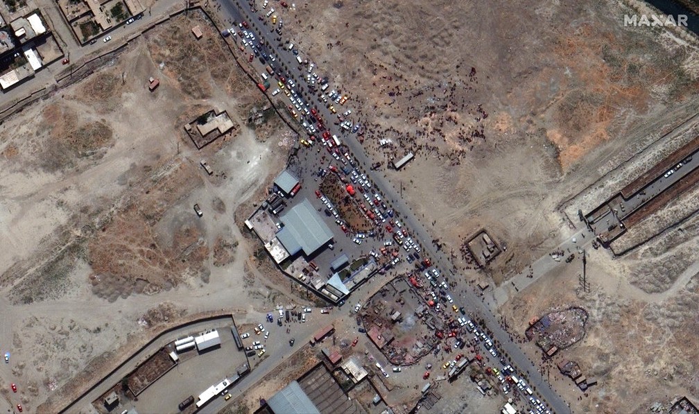 Imagem de satélite mostra uma multidão de pessoas e tráfego intenso de automóveis na entrada norte do aeroporto internacional de Cabul na segunda-feira, agosto 23 de 2021 — Foto: Maxar Technologies/AP