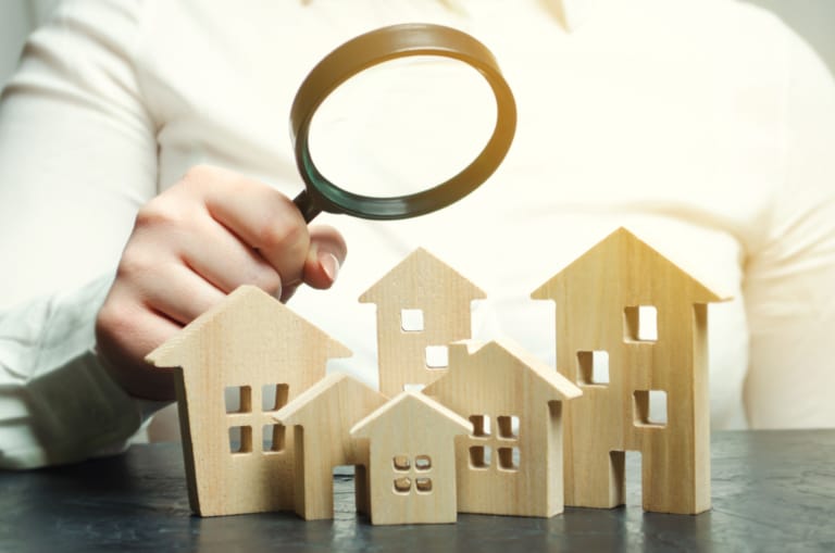 Magnifying glass over wooden homes