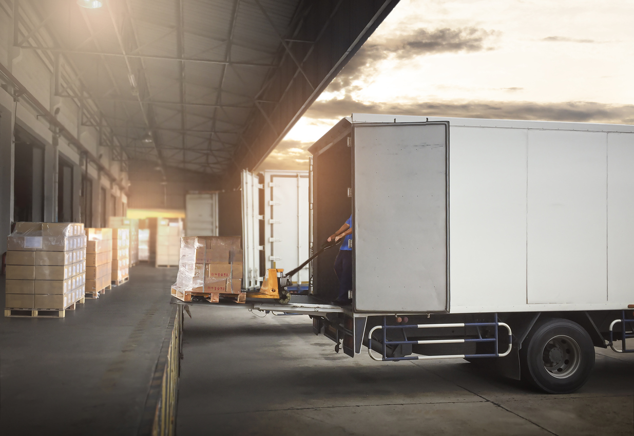 Um caminhão está carregando e descarregando mercadorias em um depósito e os produtos estão organizados seguindo as etapas do fulfillment