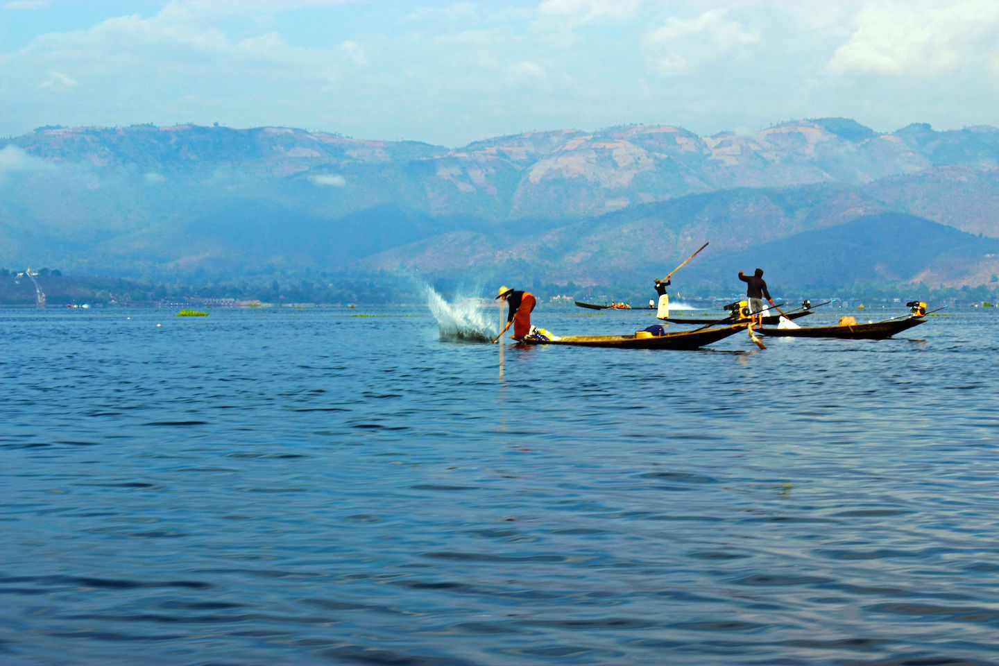 Fisherman using poles to hit the water on Inle Lake, Myanmar