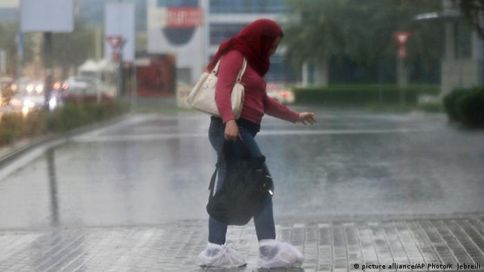 Una mujer se cubre de las lluvias en Dubai, Emiratos Árabes Unidos