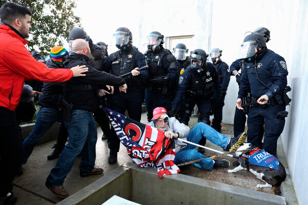 Opponents of virus restrictions clashed with police officers outside the Oregon State Capitol on Monday, while legislators met for an emergency session.