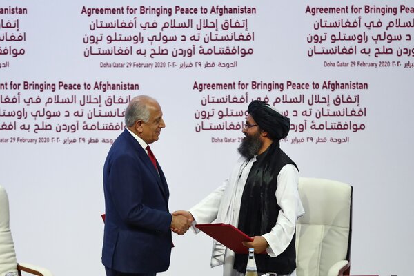 The U.S. special representative for Afghanistan reconciliation, Zalmay Khalilzad, and the Taliban co-founder Mullah Abdul Ghani Baradar shaking hands after signing a peace agreement in Qatar in February 2020.