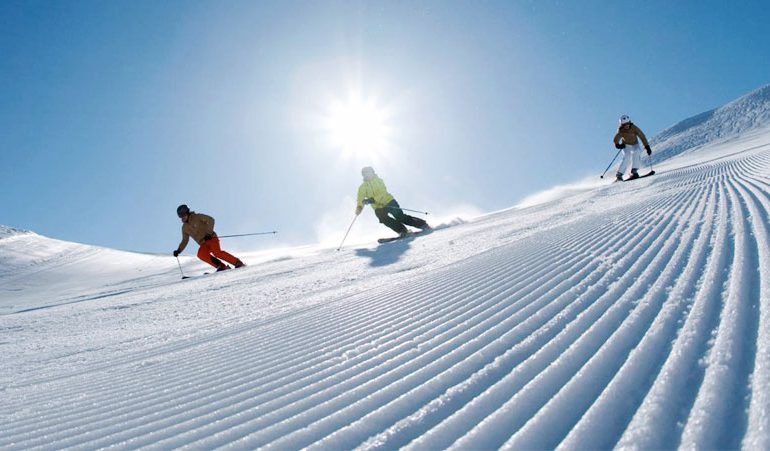 two adult skiers enjoy freshly groomed pistes during private ski lesson