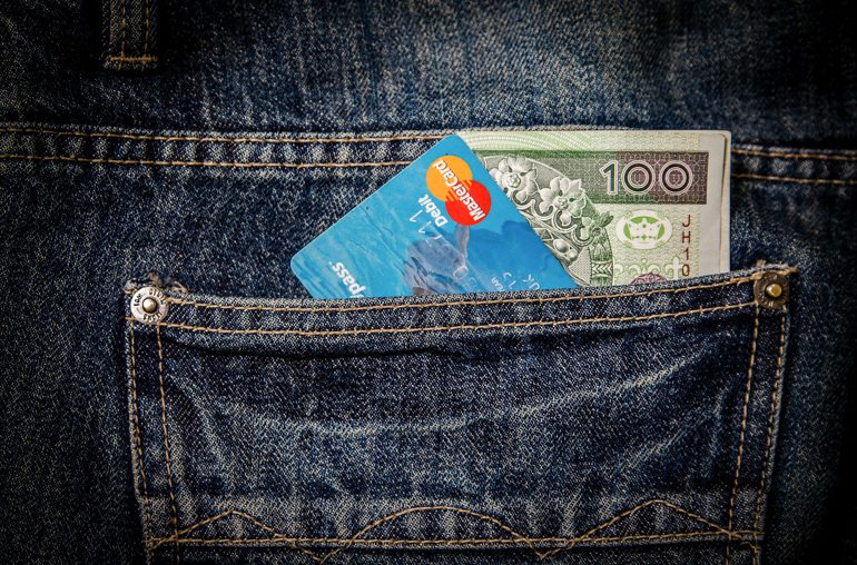 Mastercard and banknote in back pocket of jeans