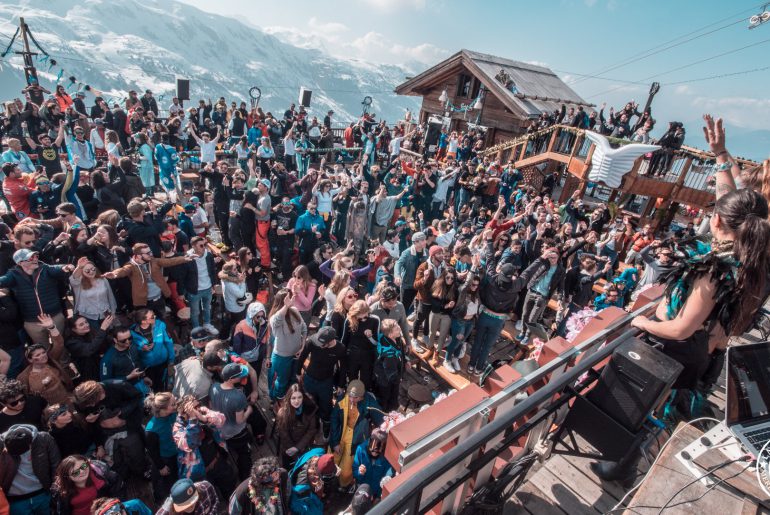 large crowd partying outdoors in the mountains at folie douce meribel