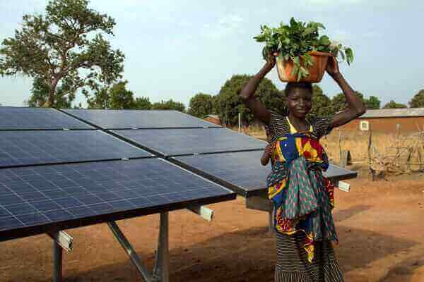 Jeune femme sénégalaise devant des panneaux solaires