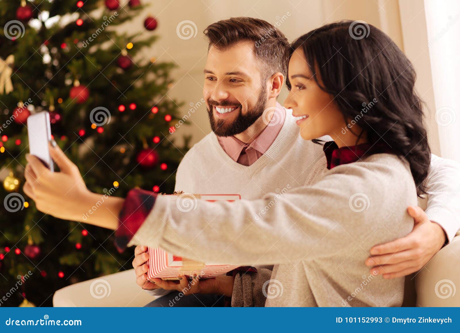 https://thumbs.dreamstime.com/z/happy-international-couple-taking-selfies-christmas-seizing-moment-happy-young-international-couple-sitting-sofa-101152993.jpg