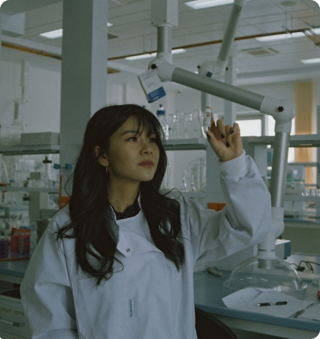 Scientific woman wearing a white lab coat running an experiment in a laboratory