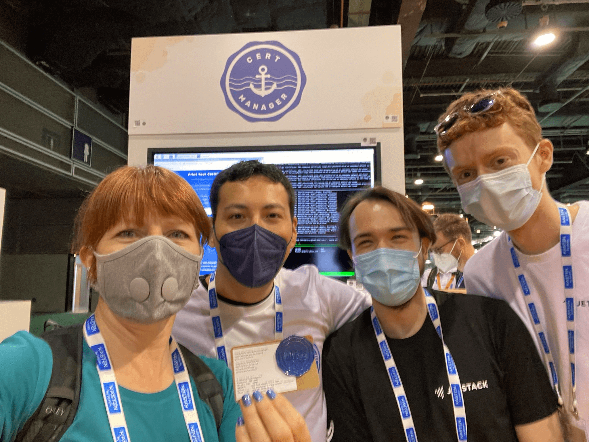Liz Rice met with the cert-manager maintainers Charlie Egan, Josh van Leeuwen, and Jake Sanders with the cert-manager booth in the background. All credits for this image go to Liz Rice who shared this picture on Twitter at https://twitter.com/lizrice/status/1527585297743110145.