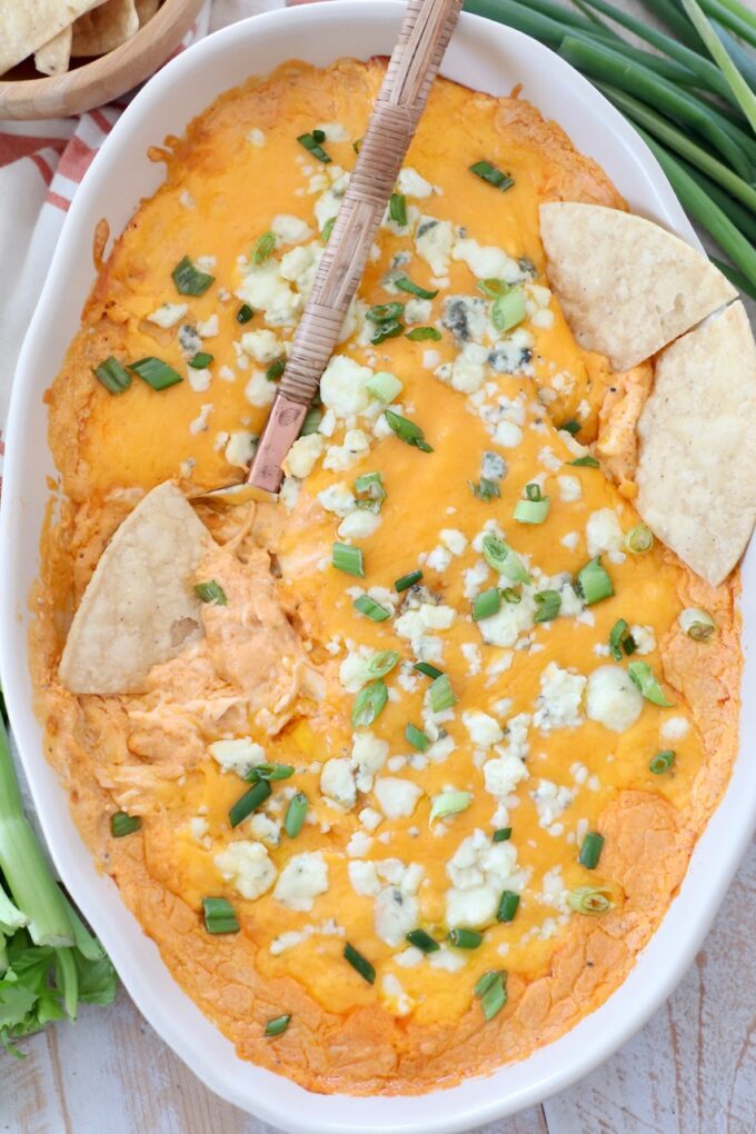 buffalo chicken dip in oval baking dish with tortilla chips