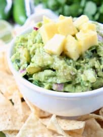 Guacamole in white bowl topped with diced pineapple
