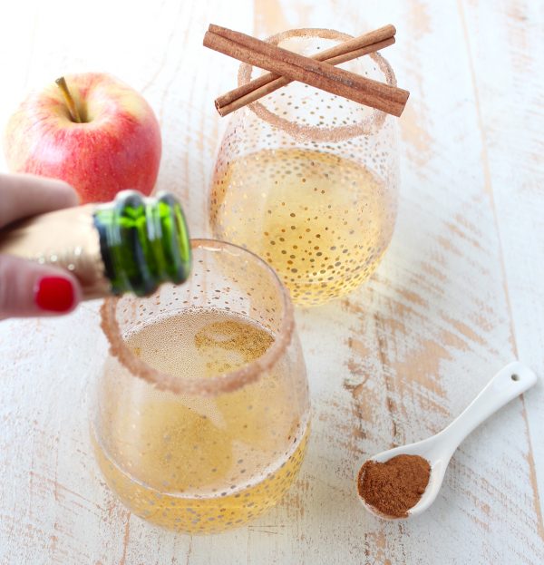 Rich apple cider is paired with sparkling champagne, vodka, maple syrup, cinnamon and nutmeg to make a festive fall apple cider champagne cocktail!