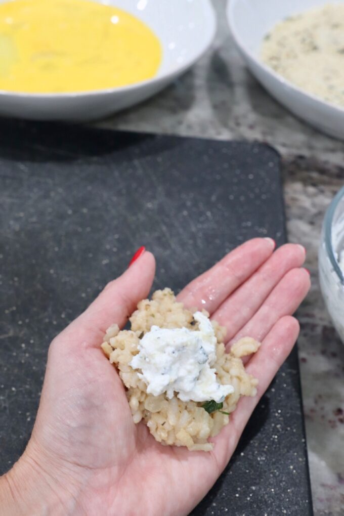 hand holding risotto with cheese on top