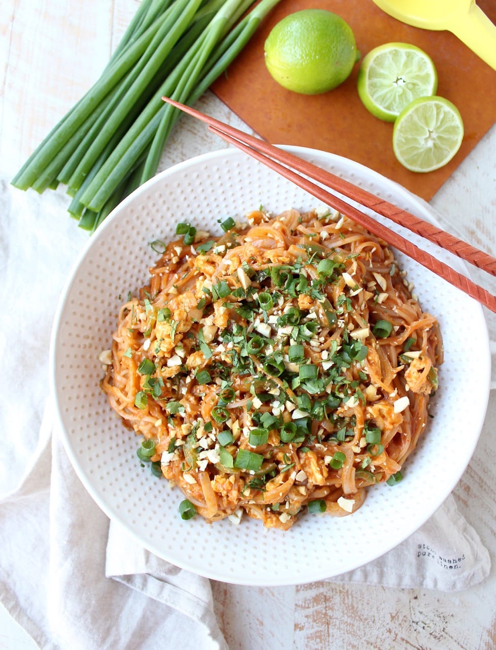 cooked Pad Thai in white bowl, topped with green onions
