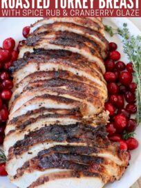 sliced roasted turkey breast on plate with fresh cranberries on the side