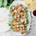 Overhead shot of chicken skewers on white plate
