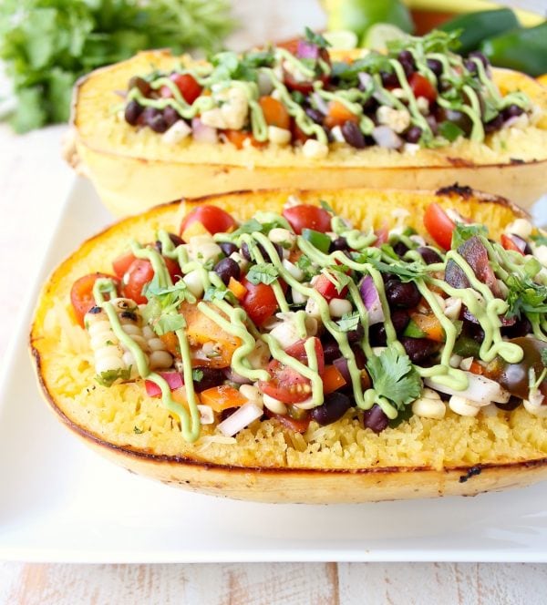 This Mexican Stuffed Squash recipe combines roasted spaghetti squash with black bean corn relish & avocado dressing for a simple vegan & gluten free meal!