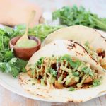 Butternut Squash tacos with creamy avocado sauce and fresh cilantro on flour tortillas