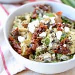 Greek eggs in bowl with feta cheese, sun dried tomatoes and green onions