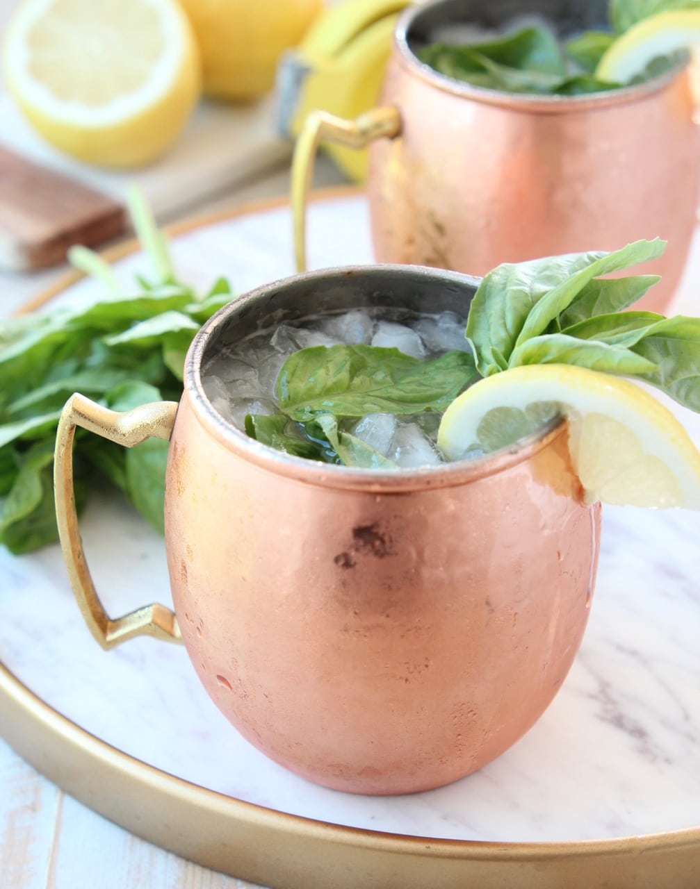 Copper mug filled with ice, vodka and ginger beer, on marble tray