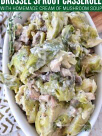 mushroom brussel sprout casserole in white baking dish with fresh thyme
