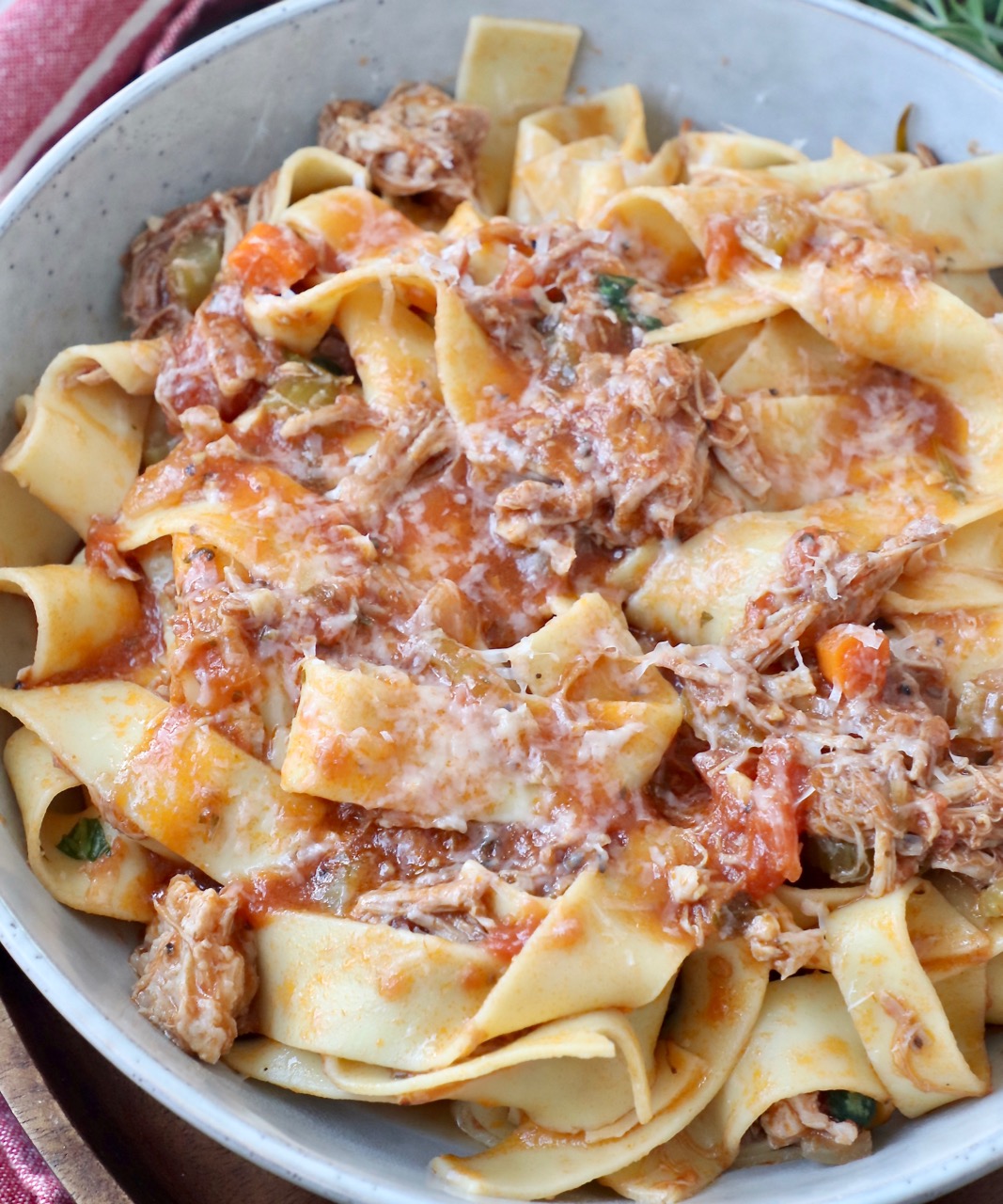 cooked pasta tossed with pork ragu sauce in a bowl