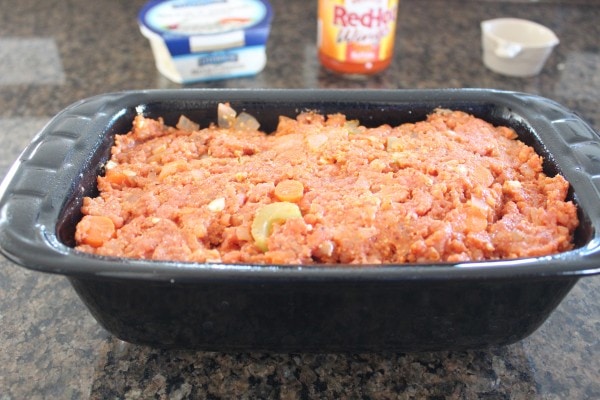 Meat mixture in a black loaf pan.