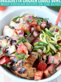 Sliced grilled chicken in bowl with tomato bruschetta and zucchini noodles