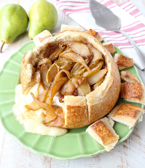 Baked brie in sourdough bread bowl with caramelized pears