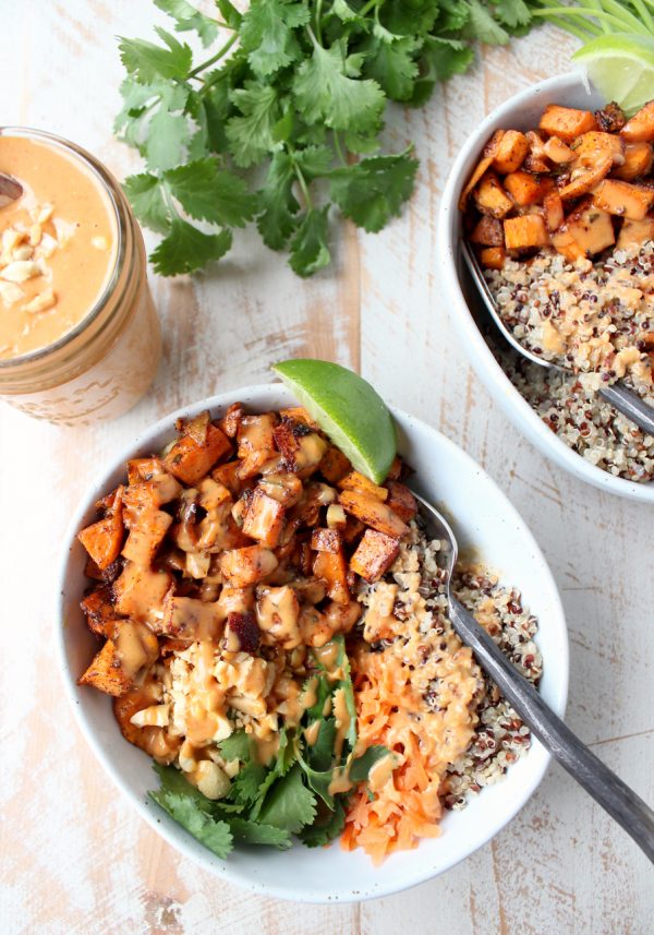 Overhead shot of roasted sweet potatoes with quinoa and thai peanut sauce in bowls