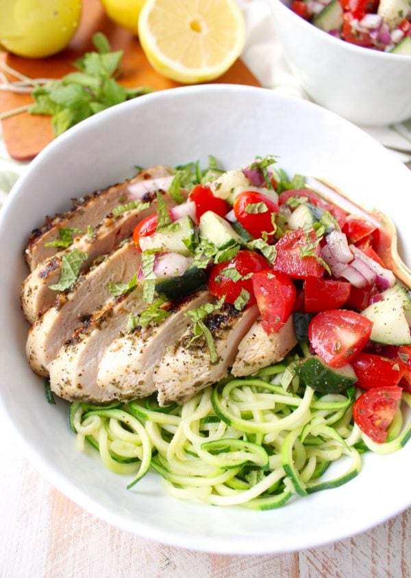 Marinated & grilled Greek Chicken is served on a bowl of zucchini noodles, topped with cucumber tomato salsa for a healthy, gluten free meal made in under 30 minutes!