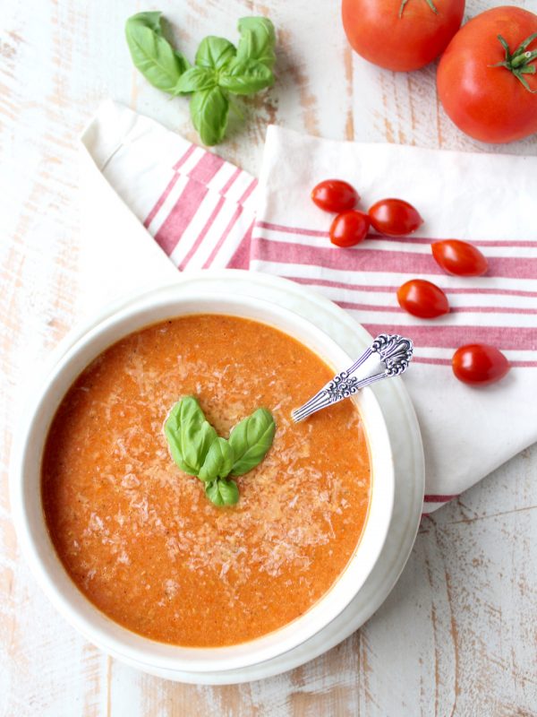 tomato soup in bowl topped with basil leaves