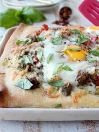 Crispy pizza crust, flavorful turkey sausage, sautéed veggies, baked eggs & parmesan cheese make up this deliciously easy breakfast pizza recipe!