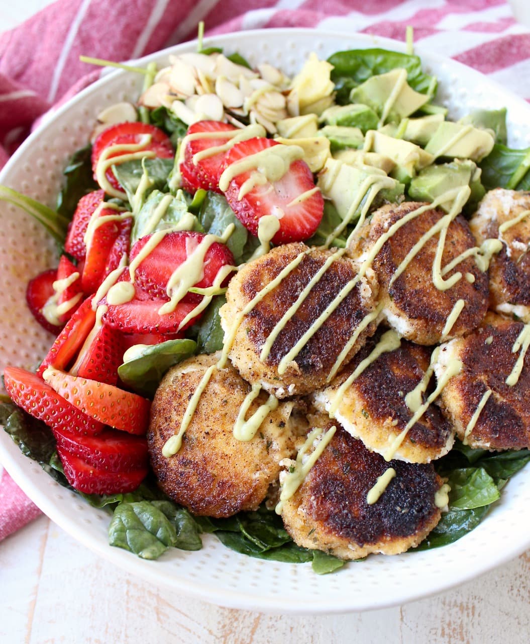 Crispy goat cheese, creamy avocado & juicy strawberries top spinach & arugula, tossed with avocado vinaigrette, for the perfect vegetarian Spring salad!