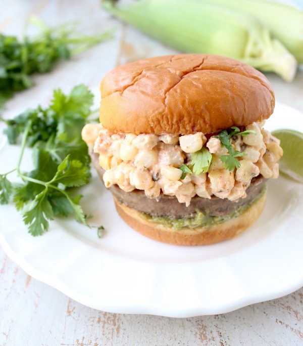 Mexican turkey burgers are covered in cotija cheese, guacamole and grilled Mexican street corn for a flavorful summer burger recipe!