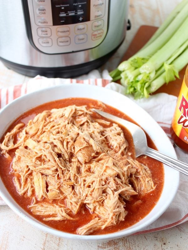 Easily make shredded buffalo chicken for tacos, dips or pasta recipes with this simple Instant Pot Buffalo Chicken recipe!