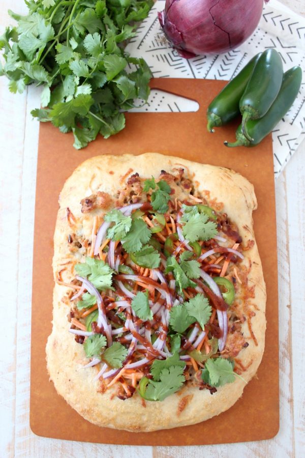 Turn your favorite banh mi sandwich into a pizza with this easy and delicious Banh Mi Pizza recipe, topped with sesame ginger ground pork, fresh carrots, jalapeños, cilantro and Sriracha!