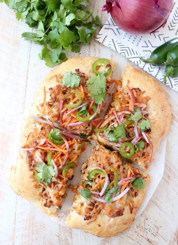 Turn your favorite banh mi sandwich into a pizza with this easy and delicious Banh Mi Pizza recipe, topped with sesame ginger ground pork, fresh carrots, jalapeños, cilantro and Sriracha!