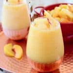 Frozen Peach Sangria in Glasses on Copper Tray with Fresh Peaches in Red Colander