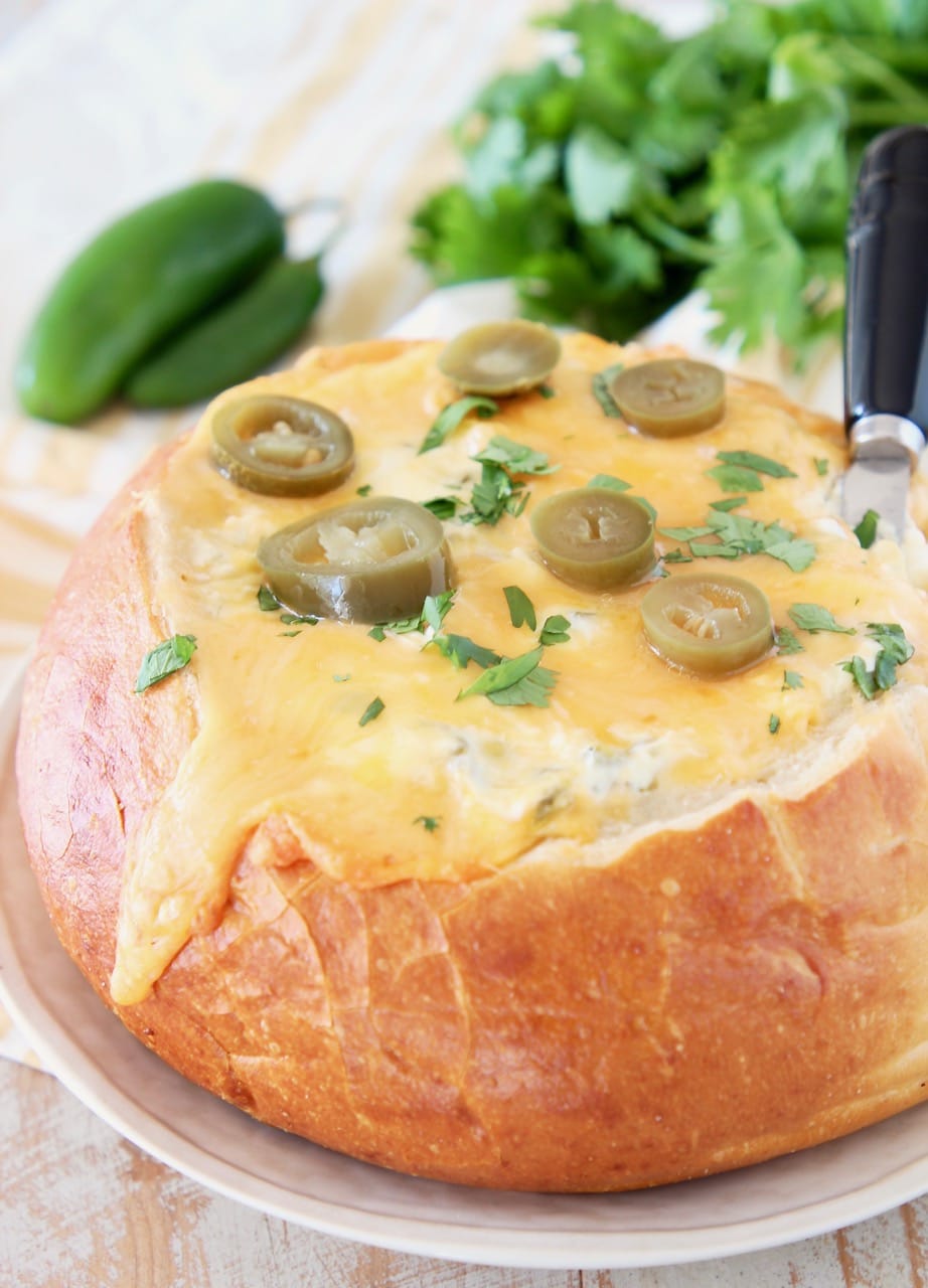 Jalapeno cheese bread bowl with pickled jalapenos and cheese spreader