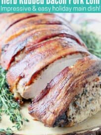 Sliced bacon wrapped pork loin on wood cutting board