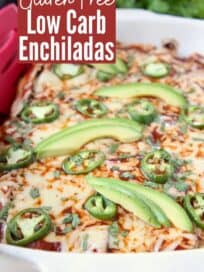 enchiladas in baking dish topped with sliced jalapenos and avocado