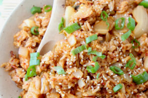 Kimchi fried rice in bowl topped with sesame seeds and diced green onions